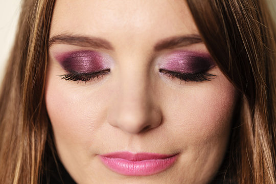 Woman closed eyes with violet dark shadows makeup