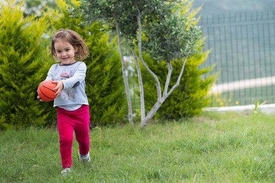 runnign child in garden with ball