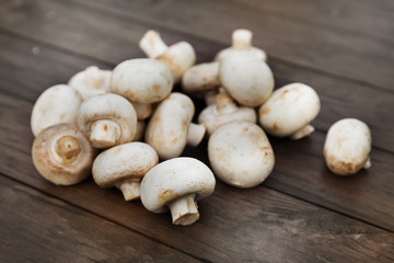 Fresh champignon mushhrooms on a wooden background
