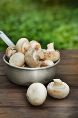 Fresh champignon mushhrooms on a wooden background