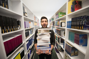 Student holding lot of books in school library