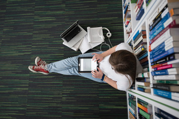 female student study in library, using tablet and searching for
