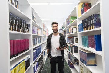 student with tablet in library