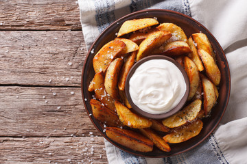 Tasty potato wedges with mayonnaise on a plate closeup. Horizontal  top view
