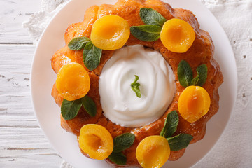 Tasty cake Savarin with apricots and mint close-up. horizontal top view
