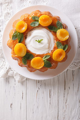 Savarin French dessert with apricots and whipped cream. vertical top view
