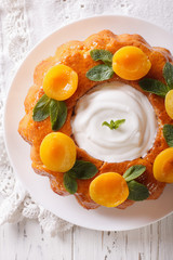 French pastries: Savarin with apricots and mint close-up. vertical top view
