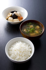 黒木目背景のごはんとみそ汁と煮物