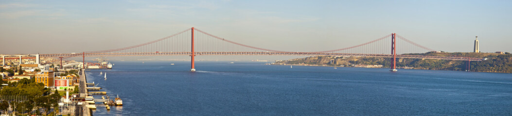 Panorama of bridge 25 de Abril on river Tagus at sunset, Lisbon,