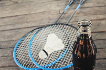 Shuttlecocks with badminton racket and cola drink
