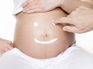 Pregnant woman puts on lotion