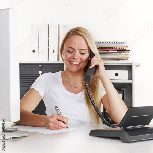 "Female office assistant has a call at the office" Stock photo and