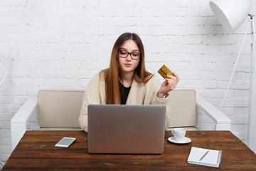 Young woman in glasses online shopping at home