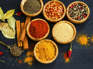 Spices powder and seeds seasoning in wooden bowls