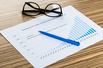 Financial paper charts and graphs on the table.