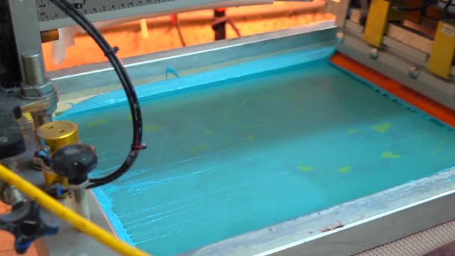 Industrial silk screen printing machine in action