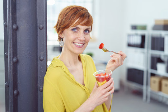frau isst einen obstsalat im b&uuml;ro