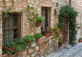 Fototapeta na wymiar Plants in pots on narrow streets of the ancient city of Spello, Umbria, Italy