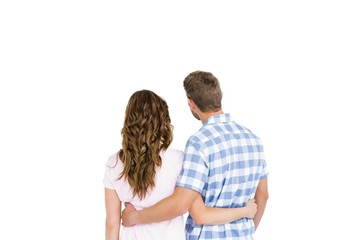 Rear view of happy young couple embracing on white background