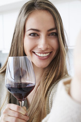 Beautiful woman with wine smiling at camera
