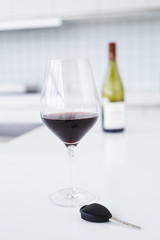 Red wine and key on kitchen worktop