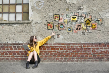 Technological woman sitting on the ground