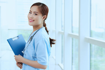 Portrait of pretty Asian nurse with folder