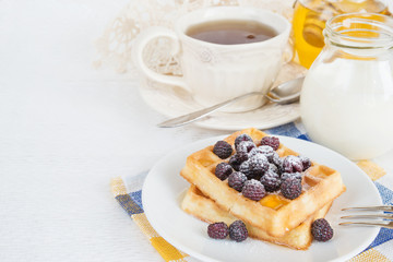 Cup of tea, waffles, milk and honey