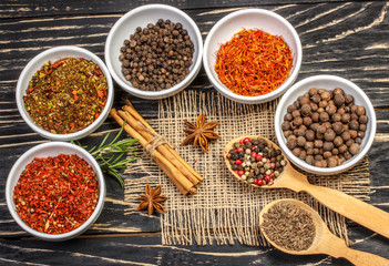 Colorful aromatic Indian spices and herbs on an old oak wooden brown background
