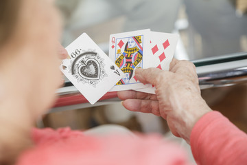 Elderly man holding cards