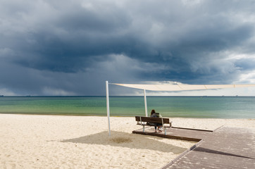 zakochana para na plaży pod parasolem 
