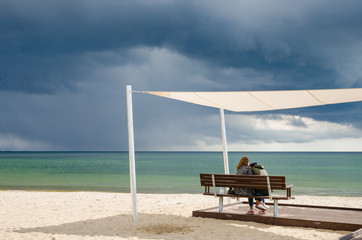zakochana para na plaży pod parasolem 
 - obrazy, fototapety, plakaty