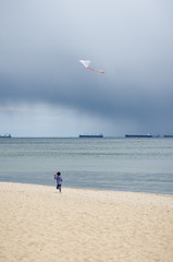 dziecko bawi się latawcem na plaży
