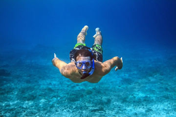 Underwater shoot of a young man snorkeling in a tropical sea - obrazy, fototapety, plakaty