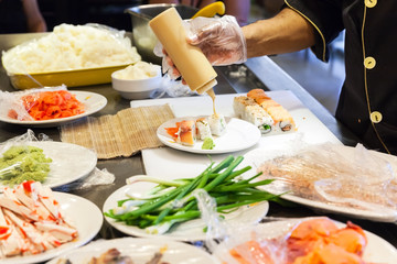 Preparing of sushi rolls with salmon