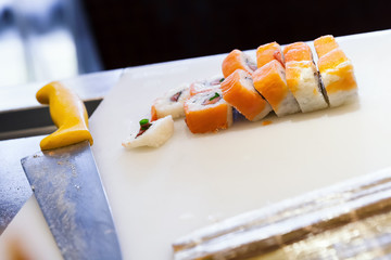 Sushi rolls with salmon lay on cutting board