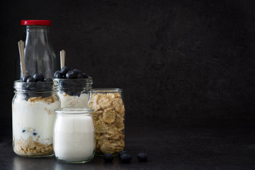 Yogurt with fresh blueberries and cereals on black background
