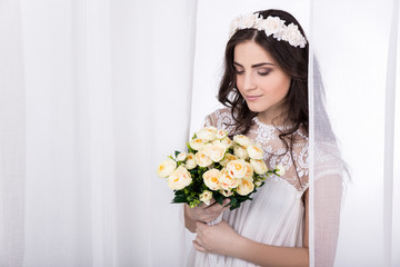 young beautiful dreaming bride in white dress with flowers