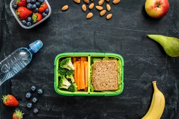 Rolgordijnen School lunch box with sandwich, vegetables, water and fruits © pinkyone