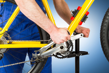 bicycle mechanic adjusting pedal on a mountain bike / fahrrad mechaniker beim montieren der Pedale...