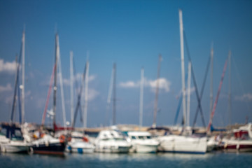 Fototapeta na wymiar Blurred background of a sail yachts harbor at sunset