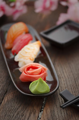 Sushi nigiri set on a black plate over wooden table