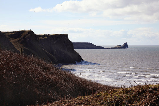 Worm's Head as seen from Rhossili Bay, Rhossili, on the west Gower Peninsular, West Glamorgan, Wales, UK, a popular Welsh coastline attraction for tourist visitors of outstanding beauty