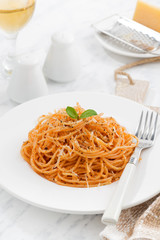 pasta with tomato sauce on a white plate, vertical, closeup