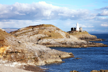 The Mumbles with it's lighthouse as seen from Bracelet Bay on the Gower Peninsular, West Glamorgan, Wales, UK, a popular Welsh coastline attraction for tourist visitors
