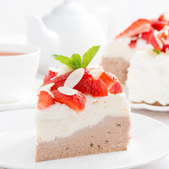 piece of cake with cream, fresh strawberries and tea