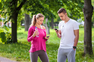 Running couple after jogging checking stats on smart phone