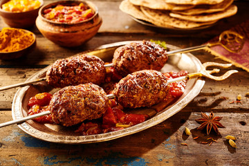 Four pieces of meat on skewers as Indian food