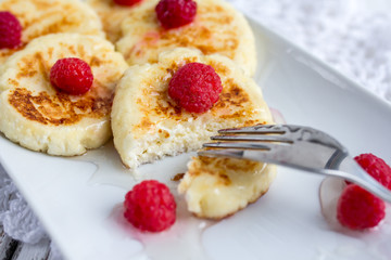 Homemade сottage cheese pancakes with raspberries and honey