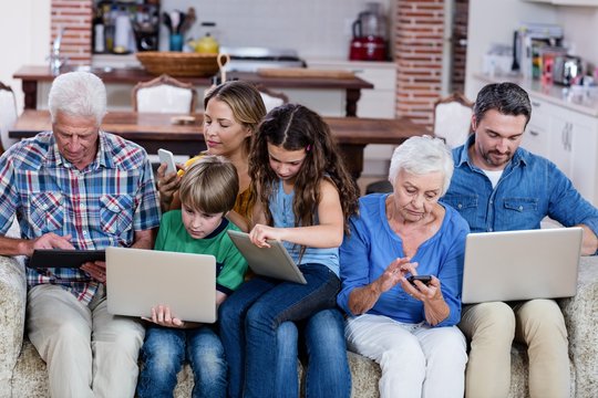 Multi-generation Family Using A Laptop, Tablet And Phone